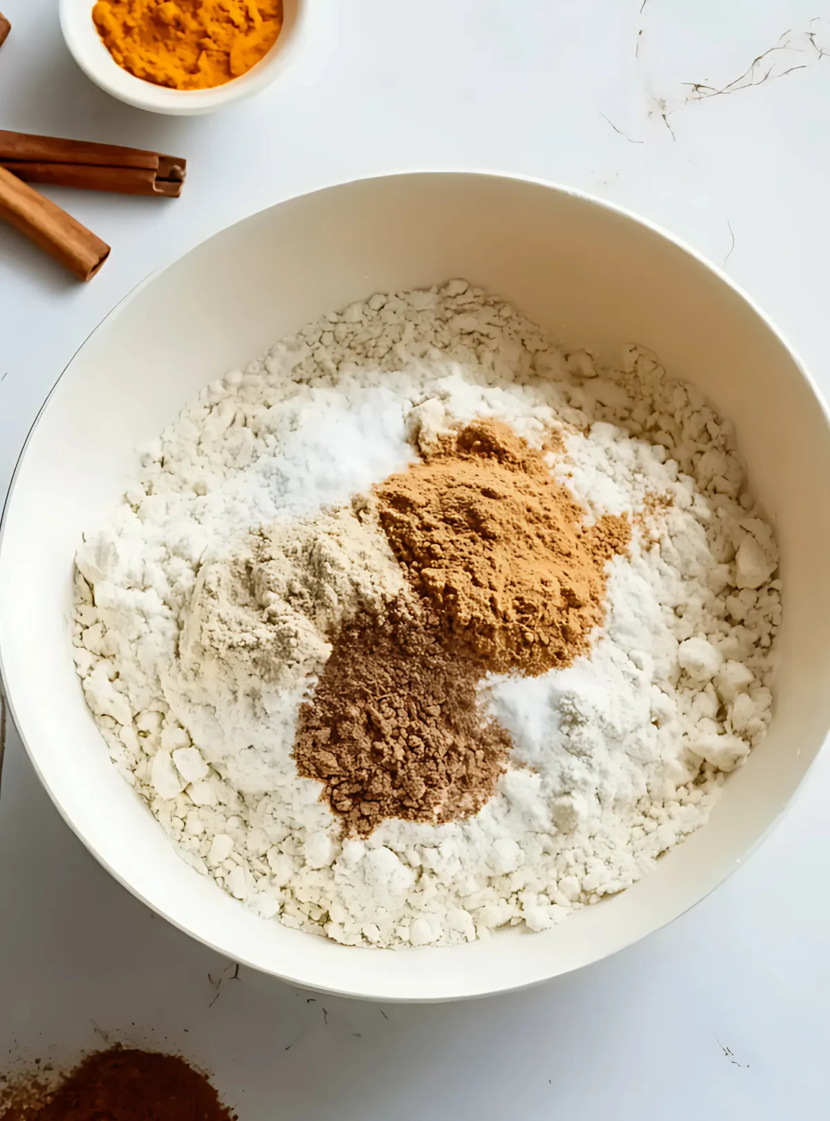 Dry ingredients including flour and spices in mixing bowl