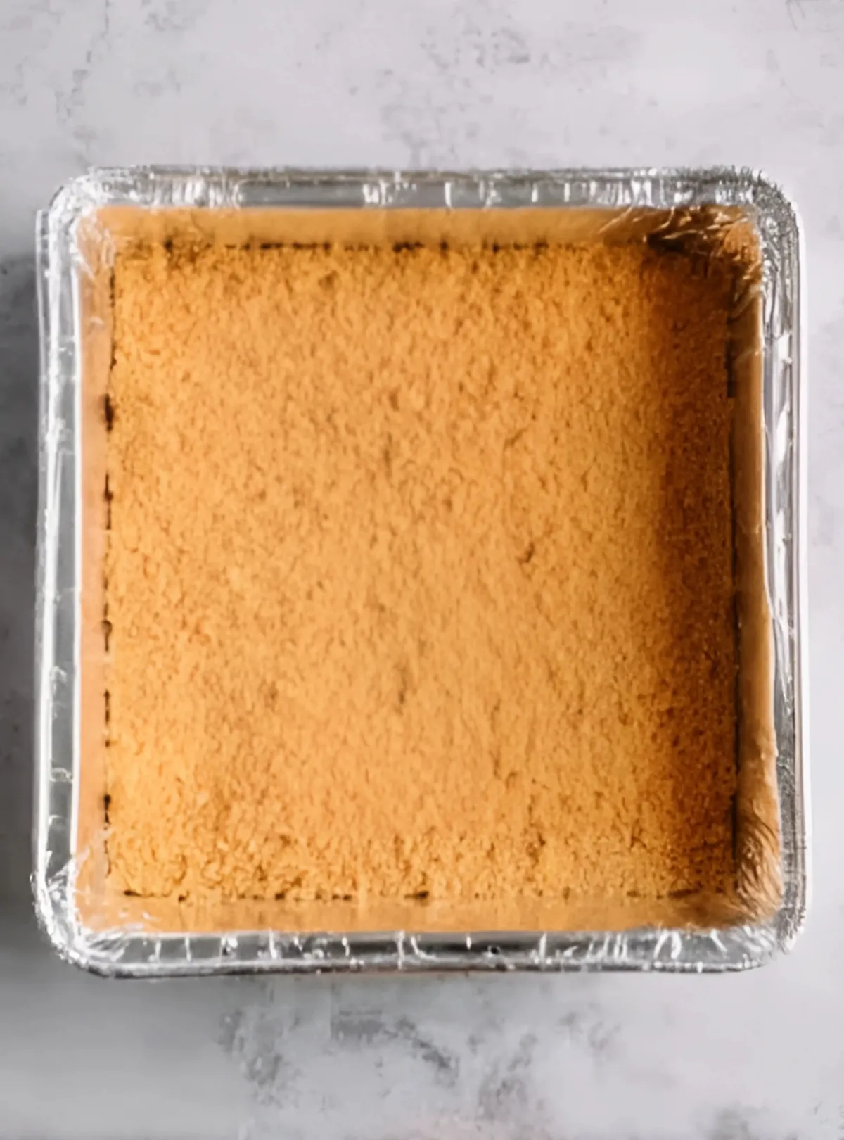 Graham cracker crust pressed in foil pan