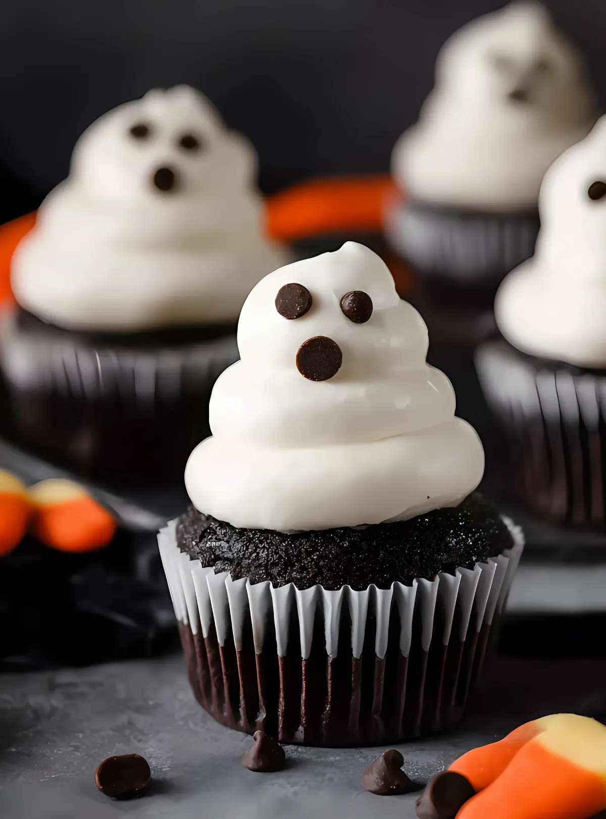 Halloween ghost cupcake with orange candy corn in background
