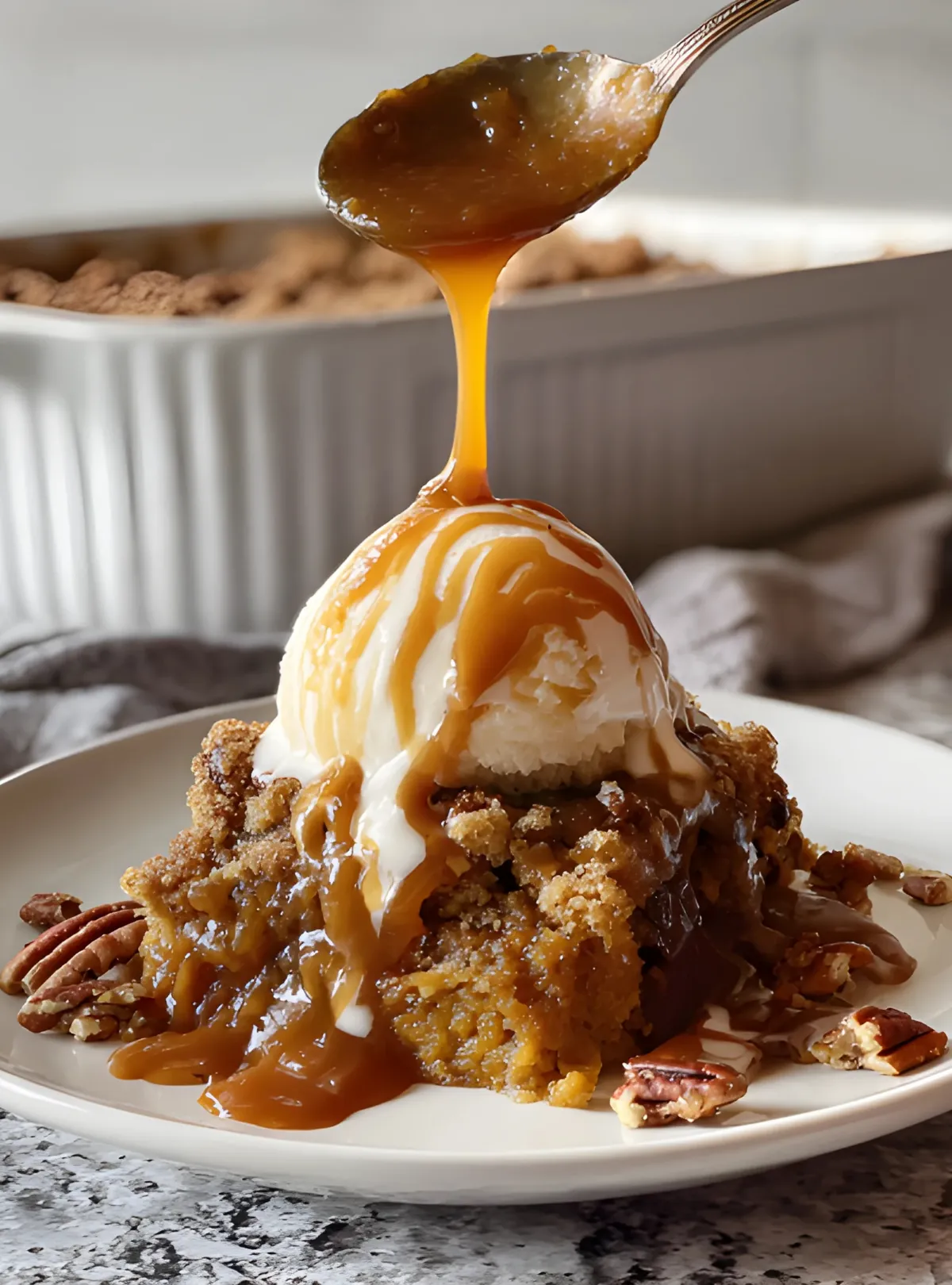spoon drizzling caramel cobbler